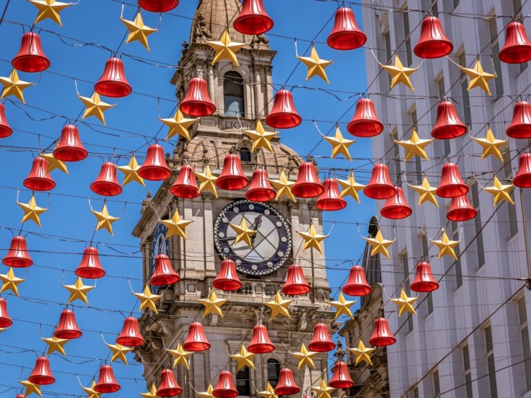 Clock tower with christmas decorations in front of it. Unwrap the magic: 7 unmissable Christmas events in Melbourne (2025 Guide)